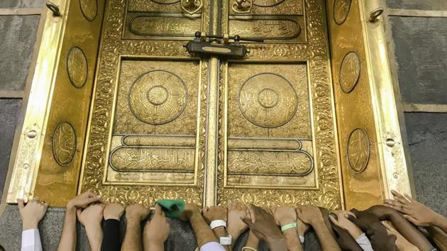 Pilgrims touch the golden door of the Kaaba, the cubic building at the Grand Mosque. For the Muslim faithful, Hajj retraces the last steps of the Prophet Mohammed and also honours the prophets Abraham and Ishmael. (Dar Yasin / AP)
