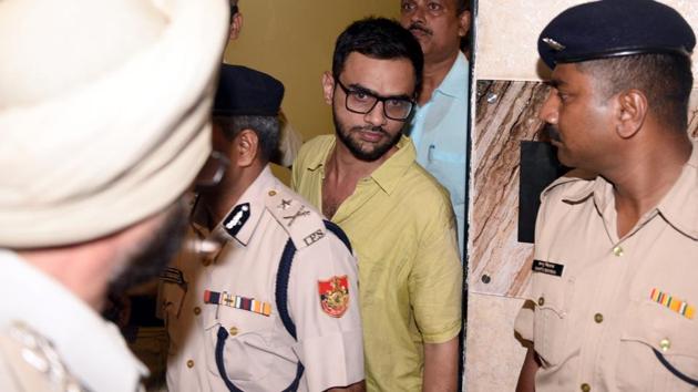 Delhi police officials with JNU student Umar Khalid who escaped unhurt after an unidentified man shot at him, outside the Constitution club at Rafi Marg in Central Delhi on August 13, 2018. (Sonu Mehta/HT Photo) Delhi police officials with JNU student Umar Khalid who escaped unhurt after an unidentified man shot at him, outside the Constitution club at Rafi Marg in Central Delhi on August 13, 2018. (Sonu Mehta/HT Photo)