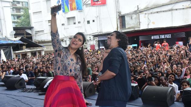 Kajol and Riddhi Sen take a selfie with students of Narsee Monjee in the background while promoting Helicopter Eela there.(Viral Bhayani) Kajol and Riddhi Sen take a selfie with students of Narsee Monjee in the background while promoting Helicopter Eela there.(Viral Bhayani)