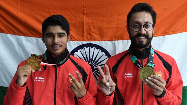 Gold medallist India's Saurabh Chaudhary (L) and bronze medallist India's Abhishek Verma pose with their medals after their victory ceremony for the 10m air pistol men's shooting final during the 2018 Asian Games in Palembang on August 21, 2018. (AFP)