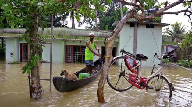 A bicycle is hung from a tree branch to avoid being washed away in flood waters as a man rows a country boat in Alappuzha. The police were on Monday given the powers to arrest those who were unwilling to leave their submerged houses. Though no arrest was reported, many were forcibly moved to relief camps. (Tibin Augustine / AP) A bicycle is hung from a tree branch to avoid being washed away in flood waters as a man rows a country boat in Alappuzha. The police were on Monday given the powers to arrest those who were unwilling to leave their submerged houses. Though no arrest was reported, many were forcibly moved to relief camps. (Tibin Augustine / AP)
