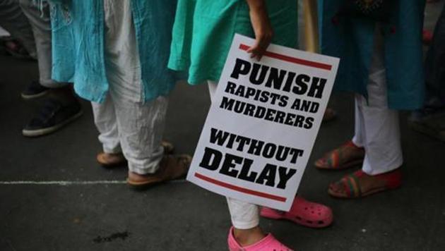 A protestor stands with a placard during a protest against rape cases in New Delhi.(AP File Photo)