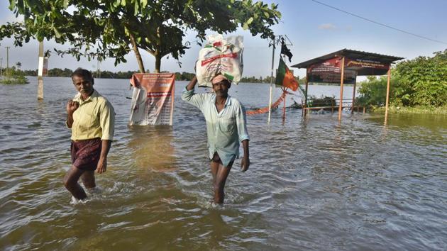 Residents wade through flooded streets to their marooned houses in the outskirts at Kuttanadu, Alappuzha district, in Kerala, India, on Tuesday.(Raj K Raj/HT PHOTO)