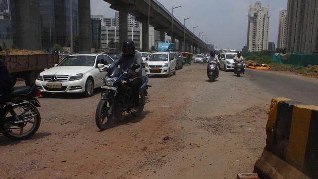 A 100-metre broken stretch on the Golf Course Road between the upscale Magnolias and Summit Apartments in DLF-5 has turned risky for commuters and motorcyclists.(Yogendra Kumar/HT Photo)