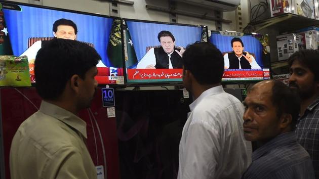 Pakistani men gather around a bank of televisions in a store as they watch a broadcast of a speech of Pakistani Prime Minister Imran Khan, as he addresses the nation, in Lahore on August 19.(AFP Photo)