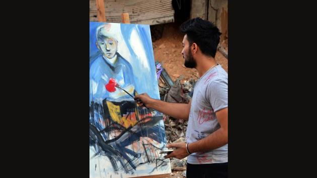 Not far from his destroyed home the camp, a 21-year-old Abdallah al-Harith dabbed bright red paint onto a canvas standing amid the grey ruins. “We’re bringing back life to a dark place,” said Harith, who fled Yarmuk several years ago, but returned after the regime ousted Islamic State group jihadists in May. (Maher Al Mounes / AFP)