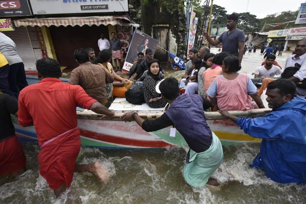 Local fishermen, volunteers and rescue personnel evacuate residents through a boat due to floods at Panadala in Kerala.(HT FILE)