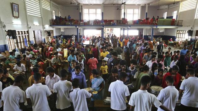Volunteers serve food to flood affected people at a relief camp set up inside a school in Kochi on August 23, 2018.(AP)