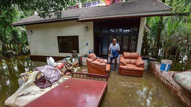 A man cleans up his house after flood water subsides, in Puthenvelikkara near Kochi.(PTI Photo)