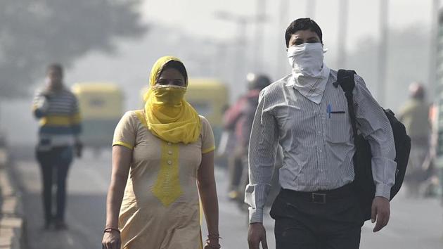 Commuters seen wearing face mask to avoid thick smog, as the air quality deteriorated sharply overnight leading to poor visibility conditions across the city, in New Delhi.(HT File Photo)