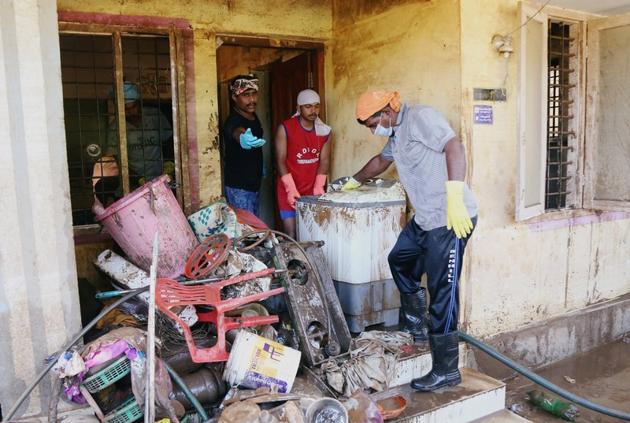 Volunteers clean a house following floods, Kochi, August 22(REUTERS)