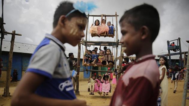 Rohingya refugee boys greet each other as girls enjoy a ride in a ferris wheel, specially brought in to the camps for Eid al Adha celebration at Kutupalong refugee camp, Bangladesh. (Altaf Qadri / AP)