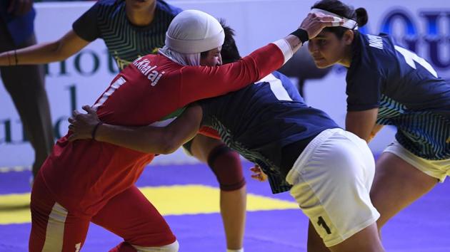 Iran's Ghazal Khalaj (L-in red) tries to a score as India's players defend during the women's team kabaddi final match between India and Iran. (AFP) Iran's Ghazal Khalaj (L-in red) tries to a score as India's players defend during the women's team kabaddi final match between India and Iran. (AFP)