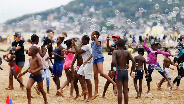 Children play on the beach in Cabourg, northwestern France, as part of the “Forgotten by the Holidays” campaign organised by the French NGO Secours Populaire for children whose families cannot afford to go on holidays. (Charly Triballeau / AFP)