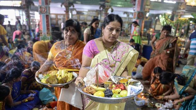 Women perform rituals during prayers to the Hindu deity Lakshmi at a temple in Hyderabad. Varalakshmi Vratham is celebrated on the Friday that precedes the full moon day of the Sravana month, as married women pray for the well being of their family members. (Noah Seelam / AFP)