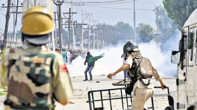 Police paramilitary troopers stand guard as Kashmiri youth protest during clashes in Srinagar. (AFP file photo) Police paramilitary troopers stand guard as Kashmiri youth protest during clashes in Srinagar. (AFP file photo)