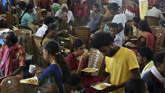 Flood affected people eat a meal as they crowd a relief camp set up inside a school in Kochi, Kerala, Thursday, Aug. 23, 2018.(AP)