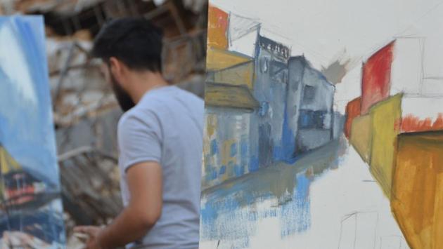 Harith and his peers stood sweeping paint across their canvases while the gentle melody of an oud -- a Middle Eastern lute -- was broadcast across the smashed concrete. He also painted an image of a small boy emerging from the ground, holding a bright red apple. “It’s supposed to represent new life,” Harith said. (Maher Al Mounes / AFP)