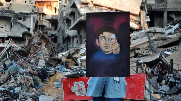Painter Hinaya Kebabi depicted a young boy with a missing eye, holding up a drawing of another eye to conceal his wound, the 22-year-old explained. “One day, I hope people will come back here to colour, not rubble,” she said. (Maher Al Mounes / AFP)