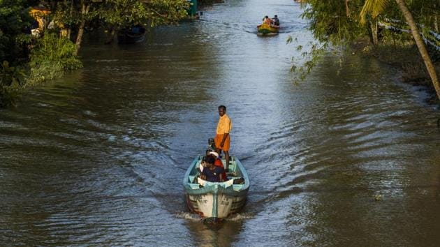 People ride boats past houses partially submerged in floodwaters in Kainakary village in the district of Alappuzha, Kerala.(Bloomberg) People ride boats past houses partially submerged in floodwaters in Kainakary village in the district of Alappuzha, Kerala.(Bloomberg)