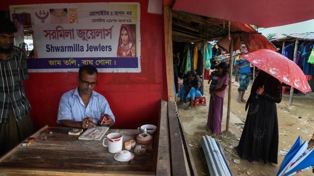 Bangladeshi gold trader Tapan Dhar repairs a gold ornament at his makeshift jewellery shop in the Thengkhali camp. For generations trade has diluted ethnic and religious rivalries among the Rakhine, Rohingya and Bangladeshis who flit between the two countries. Commerce was barely interrupted as scores of Rohingya villages were torched in August last year, sparking an exodus of around 700,000 people by land and sea into Bangladesh. (Chandan Khanna / AFP) Bangladeshi gold trader Tapan Dhar repairs a gold ornament at his makeshift jewellery shop in the Thengkhali camp. For generations trade has diluted ethnic and religious rivalries among the Rakhine, Rohingya and Bangladeshis who flit between the two countries. Commerce was barely interrupted as scores of Rohingya villages were torched in August last year, sparking an exodus of around 700,000 people by land and sea into Bangladesh. (Chandan Khanna / AFP)