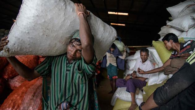Workers carry sacks of rice from Myanmar to waiting trucks at Teknaf port. Commerce was barely interrupted as scores of Rohingya villages were torched in August last year. The skies were heavy with smoke, but Min Min said he carried on delivering his “Made in Myanmar” cargo to Teknaf port -- rice, ginger, make-up, noodles and the “ainshi” chestnuts ubiquitous at Rohingya snack stalls. (Ed Jones / AFP) Workers carry sacks of rice from Myanmar to waiting trucks at Teknaf port. Commerce was barely interrupted as scores of Rohingya villages were torched in August last year. The skies were heavy with smoke, but Min Min said he carried on delivering his “Made in Myanmar” cargo to Teknaf port -- rice, ginger, make-up, noodles and the “ainshi” chestnuts ubiquitous at Rohingya snack stalls. (Ed Jones / AFP)