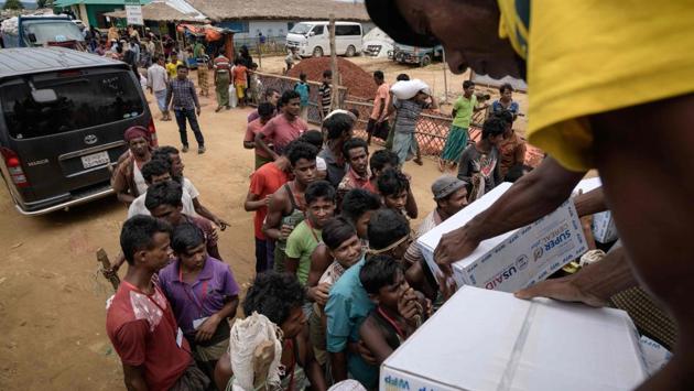 Rohingya refugees collect boxes of food aid at a distribution point in the Kutupalong camp. The makeshift Rohingya camps have now congealed into tent cities spread out across hills and farmland. They contain new and dynamic economies, pump-primed by donor money and driven by a captive market of hundreds of thousands in need of food, shelter, work and -- for those who can afford it -- consumer goods. (Ed Jones / AFP) Rohingya refugees collect boxes of food aid at a distribution point in the Kutupalong camp. The makeshift Rohingya camps have now congealed into tent cities spread out across hills and farmland. They contain new and dynamic economies, pump-primed by donor money and driven by a captive market of hundreds of thousands in need of food, shelter, work and -- for those who can afford it -- consumer goods. (Ed Jones / AFP)
