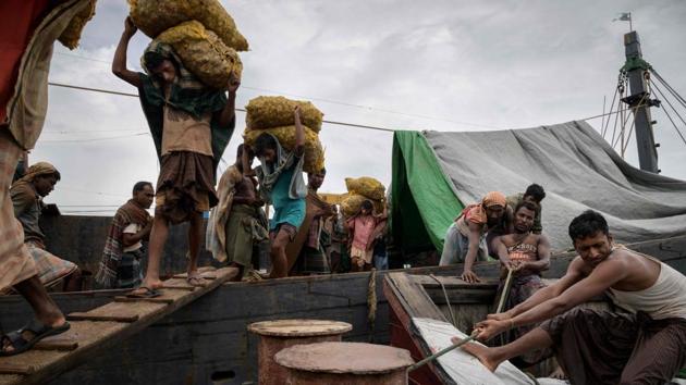 Captain Min Min, a Buddhist from Myanmar, looks on as a stream of Muslim Rohingya labourers zig-zag up narrow gangplanks hauling sacks of ginger from his boat onto Bangladeshi soil -- one of many seizing the economic opportunities presented by a refugee crisis. “I don’t worry about conflict... everything is just business,” the ethnic Rakhine skipper said waiting for his nine-tonne cargo to be unloaded. (Ed Jones / AFP) Captain Min Min, a Buddhist from Myanmar, looks on as a stream of Muslim Rohingya labourers zig-zag up narrow gangplanks hauling sacks of ginger from his boat onto Bangladeshi soil -- one of many seizing the economic opportunities presented by a refugee crisis. “I don’t worry about conflict... everything is just business,” the ethnic Rakhine skipper said waiting for his nine-tonne cargo to be unloaded. (Ed Jones / AFP)