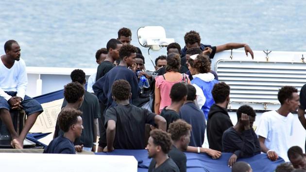 Migrants aboard the Italian Coast Guard ship Diciotti gather as they await decisions in the port of Catania, Italy, on Friday. Italy’s populist government warned it would pull European Union funding unless it agrees to take some of the 150 people stranded on an Italian coastguard ship Friday, sparking a fresh immigration row with the bloc. (AP Photo) Migrants aboard the Italian Coast Guard ship Diciotti gather as they await decisions in the port of Catania, Italy, on Friday. Italy’s populist government warned it would pull European Union funding unless it agrees to take some of the 150 people stranded on an Italian coastguard ship Friday, sparking a fresh immigration row with the bloc. (AP Photo)