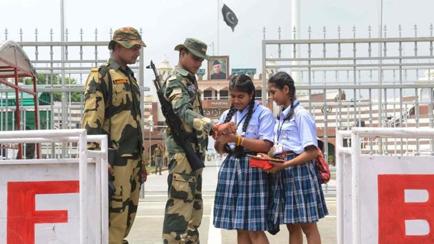 School girls tie a rakhi onto the wrists of Border Security Force (BSF) personnel during celebrations ahead of the Raksha Bandhan festival, on August 23, 2018 at the India-Pakistan Wagah Border Post about 35kms from Amritsar, Punjab. (Narinder Nanu / AFP) School girls tie a rakhi onto the wrists of Border Security Force (BSF) personnel during celebrations ahead of the Raksha Bandhan festival, on August 23, 2018 at the India-Pakistan Wagah Border Post about 35kms from Amritsar, Punjab. (Narinder Nanu / AFP)