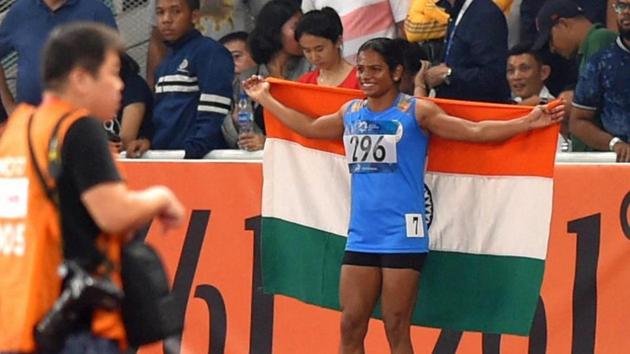 Jakarta: Silver medal winner Indian athlete Dutee Chand celebrates with national tricolour during the women's 100m final track event at the 18th Asian Games 2018 in Jakarta, Indonesia on Sunday, Aug 26, 2018. (PTI) Jakarta: Silver medal winner Indian athlete Dutee Chand celebrates with national tricolour during the women's 100m final track event at the 18th Asian Games 2018 in Jakarta, Indonesia on Sunday, Aug 26, 2018. (PTI)