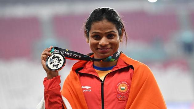 Silver medallist India's Dutee Chand celebrate during the victory ceremony for the women's 100m athletics event.(AFP)