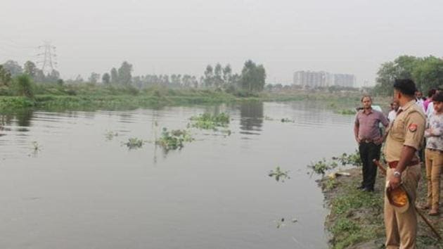 Police at the Hindon river bank in Ghaziabad. A 30-year old police sub-inspector and his mother escaped after their car plunged into a canal but the man allegedly drowned minutes later while trying to recover a bag from the vehicle on Sunday in Krishna district of Andhra Pradesh, police said.(Representative Image/HT Photo)