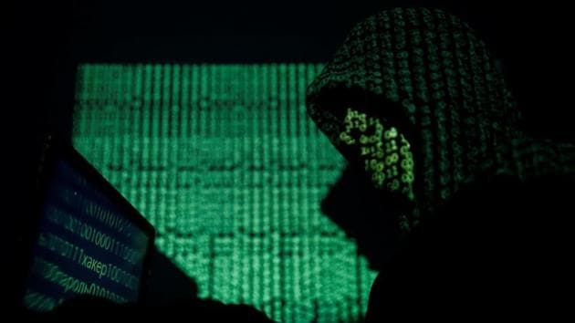 A hooded man holds a laptop computer as cyber code is projected on him in this illustration picture taken on May 13, 2017. REUTERS/Kacper Pempel/Illustration(REUTERS)