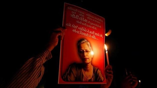 People hold placards and candles during a vigil for Gauri Lankesh, a senior Indian journalist who was shot dead outside her home by unidentified assailants in Bengaluru on September 5, 2017.(Reuters)
