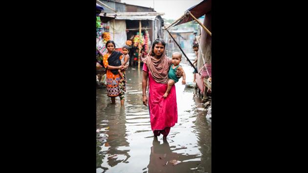 Ruby Begum’s four children have neven seen a village. In this Dhaka slum that remains inundated most of the year, her stories are like fairytales. But even the village of her stories is now underwater after years of river erosion. The children cry every night from infected feet and injuries, but there is only ever enough money to eat or buy medicine. Her life in heaven has turned hell in Dhaka, Ruby says. (GMB Akash)