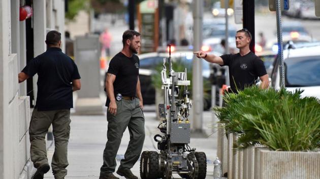 Bomb squad police prepare a robot to enter a parking garage a block away from the scene of a multiple shooting at the Jacksonville Landing on Sunday.(AP)