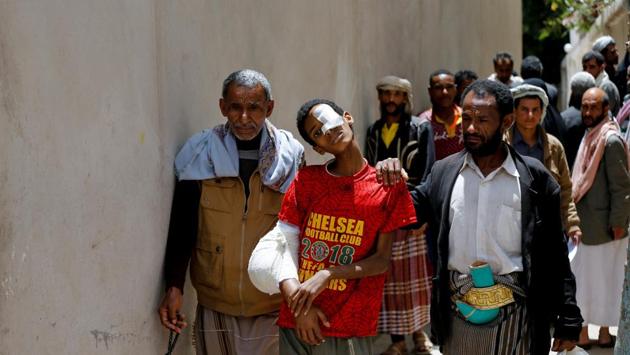 A boy with cancer is helped by his father at The National Oncology Centre. The Saudi-led alliance has imposed stringent measures on maritime trade to Yemen in an effort to choke off arms supplies to the Houthis, who still control the most populous areas including Sanaa. But the measures have also slowed the flow of desperately needed aid supplies. (Khaled Abdullah / REUTERS)