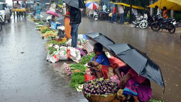 Vendors sell their vegetables during monsoon rainfall, in Karad on August 26. (PTI) Vendors sell their vegetables during monsoon rainfall, in Karad on August 26. (PTI)