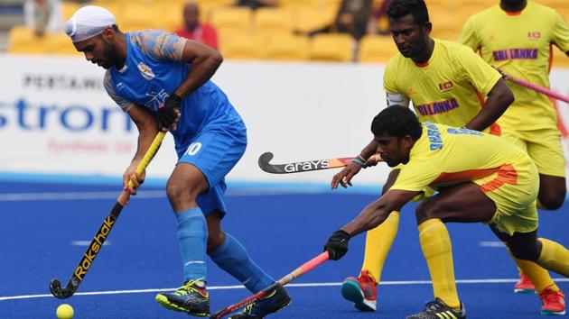 India's Simranjeet Singh (L) controls the ball as Sri Lanka's Meegahamulla Gedara H. Dharmarathne (bottom R) during the men's hockey pool A match between India and Sri Lanka. (AFP) India's Simranjeet Singh (L) controls the ball as Sri Lanka's Meegahamulla Gedara H. Dharmarathne (bottom R) during the men's hockey pool A match between India and Sri Lanka. (AFP)