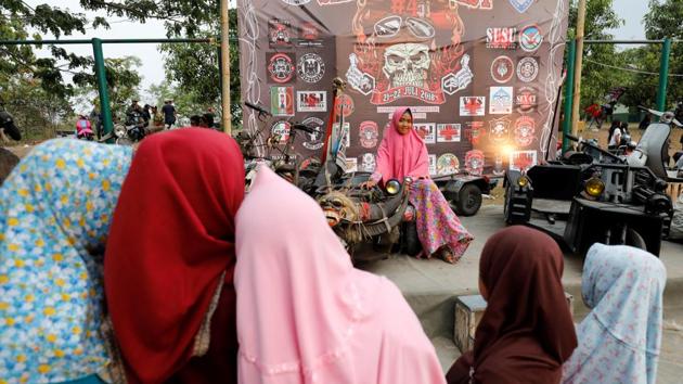Local girls take pictures of their friend sitting on a modified extreme Vespa while briefly visiting an extreme Vespa festival. Other embellishments are up to the owners and their budgets. While many can only afford scrap metal or reused material found at a junkyard, some others splash out. (Darren Whiteside / REUTERS)