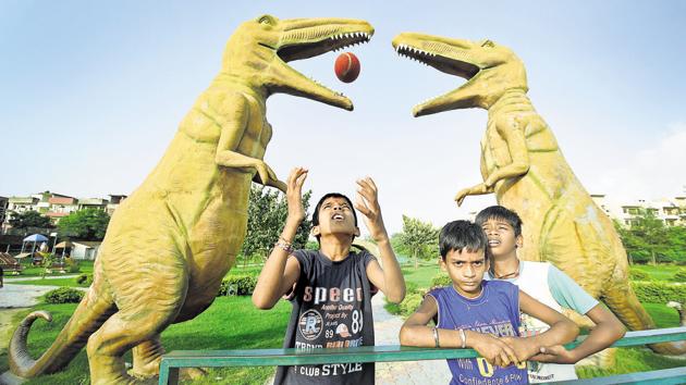 The dinosaurs park in the sector is a big hit with youngsters of the community who love playing ball in the presence of these giant animals frozen in stone.(SANJEEV SHARMA/HT)