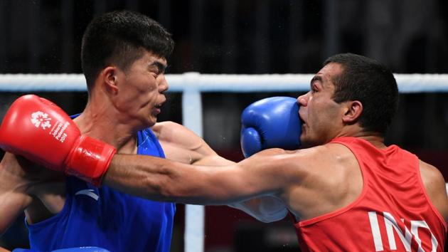 India's Krishan Vikas (red) fights with China's Touheta Erbieke Tanglatihan (blue) in their men's middle (75kg) quarter-final boxing match. (AFP)