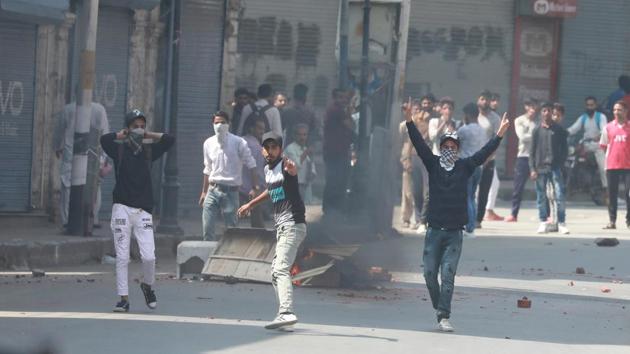 Kashmiri protesters throw stones at police and paramilitary forces during a protest at Lal Chowk area in Srinagar following rumours about scrapping of Article 35A.(Waseem Andrabi/ HT Photo)