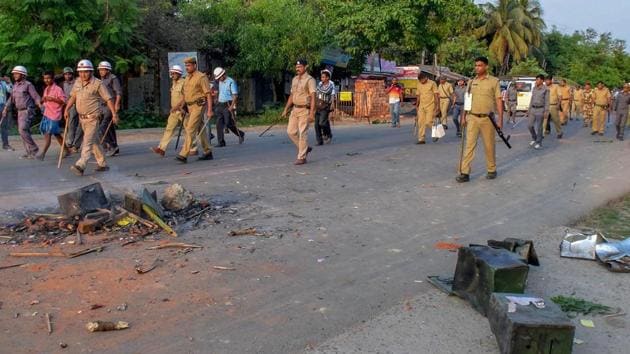 Security personnel walk past the burnt ballot boxes lying on a road after a polling station was ransacked during panchayat polls at Rampur in South Dinajpur district of West Bengal, May 14, 2018. (PTI File) Security personnel walk past the burnt ballot boxes lying on a road after a polling station was ransacked during panchayat polls at Rampur in South Dinajpur district of West Bengal, May 14, 2018. (PTI File)