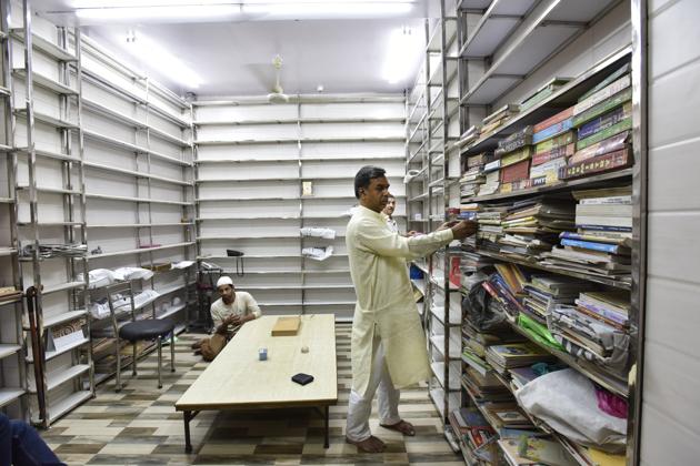 Mohammad Naeem, co-founder of Hazrat Shah Waliullah Library supervises the restocking of the new shelves, part of library’s renovation.(Mohd Zakir/HT PHOTO)