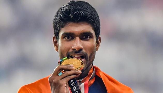Gold medallist athlete Jinson Johnson poses for photographs during the medal ceremony for the men's 1500m event. (PTI)
