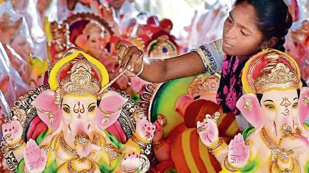 A woman artist painting an idol of Lord Ganesha at a roadside workshop ahead of Ganesh Chaturathi in Amritsar on Tuesday. (HT Photo) A woman artist painting an idol of Lord Ganesha at a roadside workshop ahead of Ganesh Chaturathi in Amritsar on Tuesday. (HT Photo)