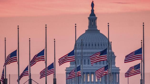 Flags flying a half-staff in honour of deceased Senator John McCain, R-Ariz., frame the US Capital at daybreak in Washington. (J. David Ake / AP)