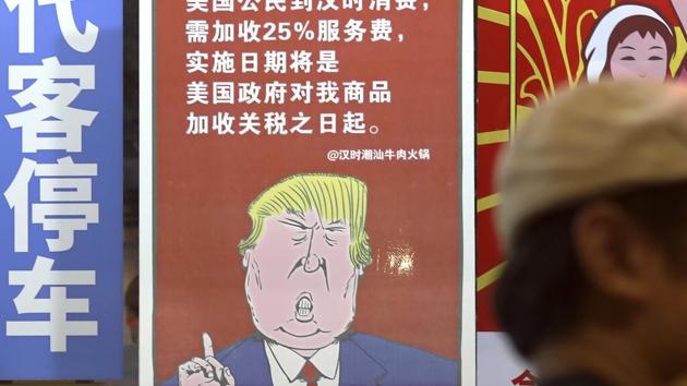 A man walks by a poster depicting a mural of US President Donald Trump speaking on the trade war against China, on display outside a restaurant in Guangzhou in south China's Guangdong province. (AP File Photo) A man walks by a poster depicting a mural of US President Donald Trump speaking on the trade war against China, on display outside a restaurant in Guangzhou in south China's Guangdong province. (AP File Photo)